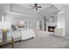 Bright main bedroom featuring a tray ceiling, fireplace, sitting area, and neutral decor at 7005 Camrose Crossing Ln, Matthews, NC 28104