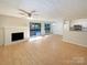 Open concept living area showcases wood floors, a brick fireplace, and flows into the kitchen at 7116 Winery Ln, Charlotte, NC 28227