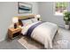 Staged bedroom with neutral colors and ample natural light from a window at 8026 Regent Park Ln, Charlotte, NC 28210