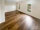 Bright bedroom with wood-look flooring and ample natural light from two windows at 8026 Regent Park Ln, Charlotte, NC 28210