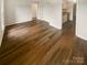 Open living room with wood-look floors, leading to hallway and kitchen at 8026 Regent Park Ln, Charlotte, NC 28210