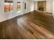 Open-concept living room with sleek hardwood floors and a stone fireplace at 8026 Regent Park Ln, Charlotte, NC 28210