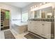 Luxurious bathroom with a soaking tub, double vanity, and elegant tile accents at 8428 Westmoreland Lake Dr, Cornelius, NC 28031