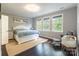 Sunlit bedroom featuring a large window, white furnishings, and dark hardwood floors at 8428 Westmoreland Lake Dr, Cornelius, NC 28031