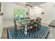 Bright dining room features a modern light fixture, and a stylish blue rug complementing the wood floors at 8428 Westmoreland Lake Dr, Cornelius, NC 28031