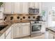 Bright kitchen with stainless steel oven and microwave, granite counters, and white cabinets at 8428 Westmoreland Lake Dr, Cornelius, NC 28031