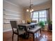 Warm dining room with a dark wood table, padded chairs, and a bench, lit by a chandelier and natural light at 9904 Rocky Ford Club Rd, Charlotte, NC 28269
