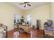 Bright home office with two windows, yellow walls, hardwood floors, and a ceiling fan at 9904 Rocky Ford Club Rd, Charlotte, NC 28269