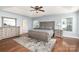 Main bedroom with trey ceiling, hardwood floors, neutral paint, large bed, and ample natural lighting at 9904 Rocky Ford Club Rd, Charlotte, NC 28269