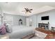 Main bedroom features a tray ceiling, a ceiling fan, a fireplace, a dresser, and hardwood floors at 9904 Rocky Ford Club Rd, Charlotte, NC 28269