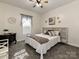 Neutral bedroom with carpet, ceiling fan, decorative bed frame, and a side table at 1009 Preston Dr, Lowell, NC 28098