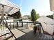 Outdoor deck featuring a swing, a small table with chairs, potted flowers, and deck boards at 1009 Preston Dr, Lowell, NC 28098