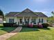Charming single-story home featuring a covered front porch with swing, lush landscaping, and a well-manicured lawn at 1009 Preston Dr, Lowell, NC 28098