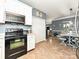 Kitchen features white cabinets, black appliances, and tile floors with a dining room view at 1009 Preston Dr, Lowell, NC 28098