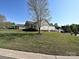 A well maintained side yard is presented with a sprawling lawn and neatly placed landscaping at 1009 Preston Dr, Lowell, NC 28098