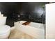 Modern bathroom with black tile accent, bathtub, and a sleek toilet at 1101 W 1St St # 405, Charlotte, NC 28202
