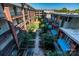 Exterior shot of an apartment courtyard with lots of greenery, plants, and trees at 1101 W 1St St # 405, Charlotte, NC 28202