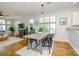 Open-concept dining area with hardwood floors, a modern table, and large windows offering ample natural light at 1101 W 1St St # 405, Charlotte, NC 28202