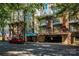 Exterior shot of multi-story condo building with brick facade, balconies, and covered parking, all beneath mature shade trees at 1101 W 1St St # 405, Charlotte, NC 28202