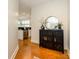 Hallway with hardwood floors leading to a kitchen, featuring a storage cabinet, mirror and plant at 1101 W 1St St # 405, Charlotte, NC 28202