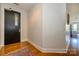 Clean, well-lit hallway with hardwood floors and a black door with glass, providing a welcoming entrance at 1101 W 1St St # 405, Charlotte, NC 28202