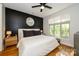 Stylish bedroom with dark accent wall, wood floors, ceiling fan and large window at 1101 W 1St St # 405, Charlotte, NC 28202