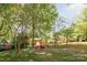 Expansive backyard with a firepit and cozy red Adirondack chairs, surrounded by mature trees and green space at 1114 Hartford Ave, Charlotte, NC 28209