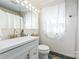 Bright bathroom features white vanity with gold faucet, modern lighting, and stylish green tile flooring at 1114 Hartford Ave, Charlotte, NC 28209