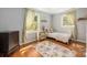 Bright bedroom with hardwood floors, natural light, and floral accents at 1114 Hartford Ave, Charlotte, NC 28209