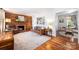 Cozy living room with wood-paneled accent wall, brick fireplace, hardwood floors, and neutral area rug at 1114 Hartford Ave, Charlotte, NC 28209