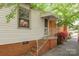 Side entrance featuring brick steps, a white railing, a storm door, and blooming azaleas at 1114 Hartford Ave, Charlotte, NC 28209