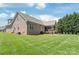 Spacious backyard featuring lush green grass, a covered porch, and mature trees, ideal for outdoor activities at 115 Ladybug Ct, Statesville, NC 28625