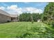 Spacious backyard featuring lush green grass, a storage shed, and mature trees, ideal for outdoor activities at 115 Ladybug Ct, Statesville, NC 28625