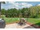 Well-manicured backyard with lush green grass, tall trees, patio area with seating, and a storage shed at 115 Ladybug Ct, Statesville, NC 28625