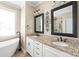 This bathroom features a double sink vanity with granite countertops and decorative mirrors at 115 Ladybug Ct, Statesville, NC 28625