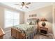 This bedroom features a ceiling fan, a bed with a floral comforter, and a window at 115 Ladybug Ct, Statesville, NC 28625