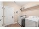 Functional laundry room with modern appliances and plenty of storage space, with a door and clock visible at 115 Ladybug Ct, Statesville, NC 28625