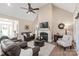 Open-concept living room with a fireplace, ceiling fan, hardwood floors and comfortable leather seating at 115 Ladybug Ct, Statesville, NC 28625