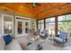 Inviting sunroom with wood paneled vaulted ceilings, french doors, and comfortable seating arrangement at 115 Ladybug Ct, Statesville, NC 28625