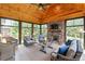 Inviting sunroom with wood paneled vaulted ceilings, stone fireplace, and comfortable seating arrangement at 115 Ladybug Ct, Statesville, NC 28625