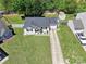 An aerial view displays a beautiful landscaped lawn with mature trees, a driveway, and a cozy home at 119 Sweet Martha Dr, Mooresville, NC 28115