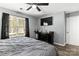 A cozy bedroom featuring hardwood floors, soft grey walls, ceiling fan, and a mounted TV at 119 Sweet Martha Dr, Mooresville, NC 28115
