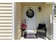 Inviting front entry with a welcoming wreath, stylish accents, and cozy outdoor seating at 119 Sweet Martha Dr, Mooresville, NC 28115