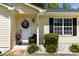 Charming home entrance with a welcoming wreath, black chair, and well-manicured landscaping at 119 Sweet Martha Dr, Mooresville, NC 28115