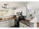 Well-lit kitchen with white cabinets, dark countertops, and modern appliances and breakfast bar at 119 Sweet Martha Dr, Mooresville, NC 28115
