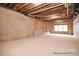 Unfinished basement shows exposed beams, concrete foundation, and natural light from windows at 122 Huntcliff Dr, Statesville, NC 28677