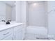 Clean bathroom features white vanity, a mirror, and a tiled bathtub with a shower at 122 Huntcliff Dr, Statesville, NC 28677