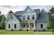 Charming two-story home with a covered porch, black trim windows, and a landscaped front yard at 122 Huntcliff Dr, Statesville, NC 28677