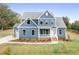 Charming two-story home with blue siding, white trim, manicured lawn and lush landscaping at 122 Huntcliff Dr, Statesville, NC 28677
