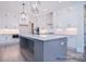Spacious kitchen features white cabinets, stainless steel appliances, and large gray island with bar seating at 122 Huntcliff Dr, Statesville, NC 28677